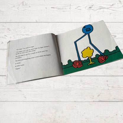 Open book with a cartoon character on a white wooden surface