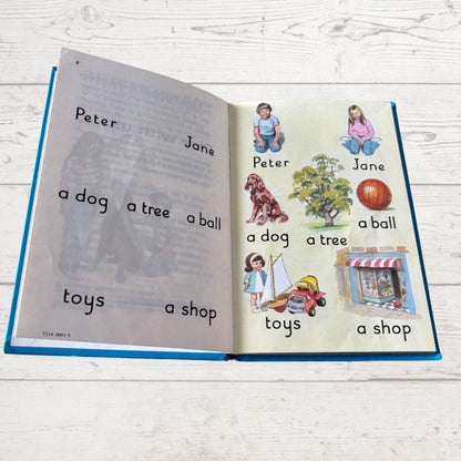 Open book with illustrations and text on a wooden surface