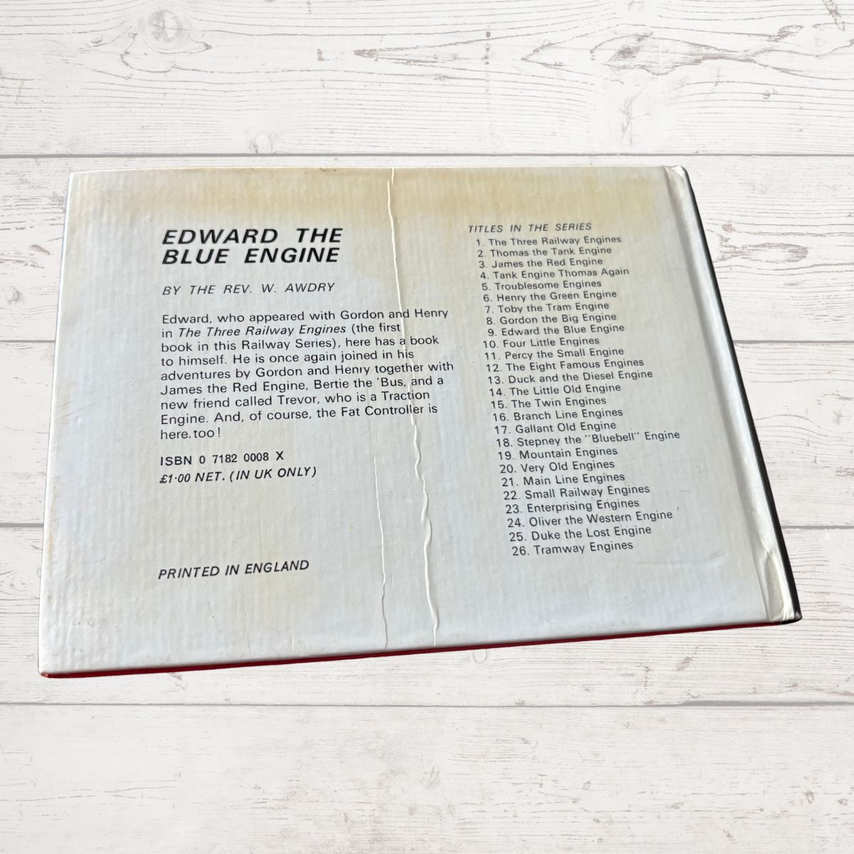 Open book showing text about 'Edward the Blue Engine' by W. Awdry on a wooden surface.