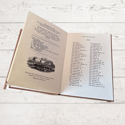 Open book on a wooden surface with text and illustrations.