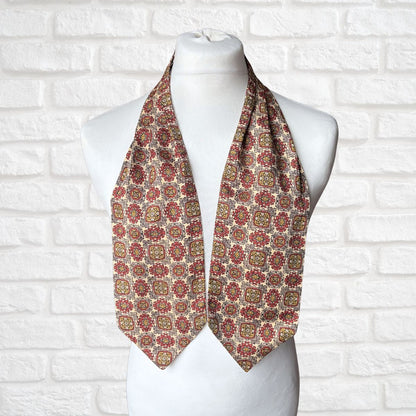 Patterned scarf on a mannequin against a white brick wall background