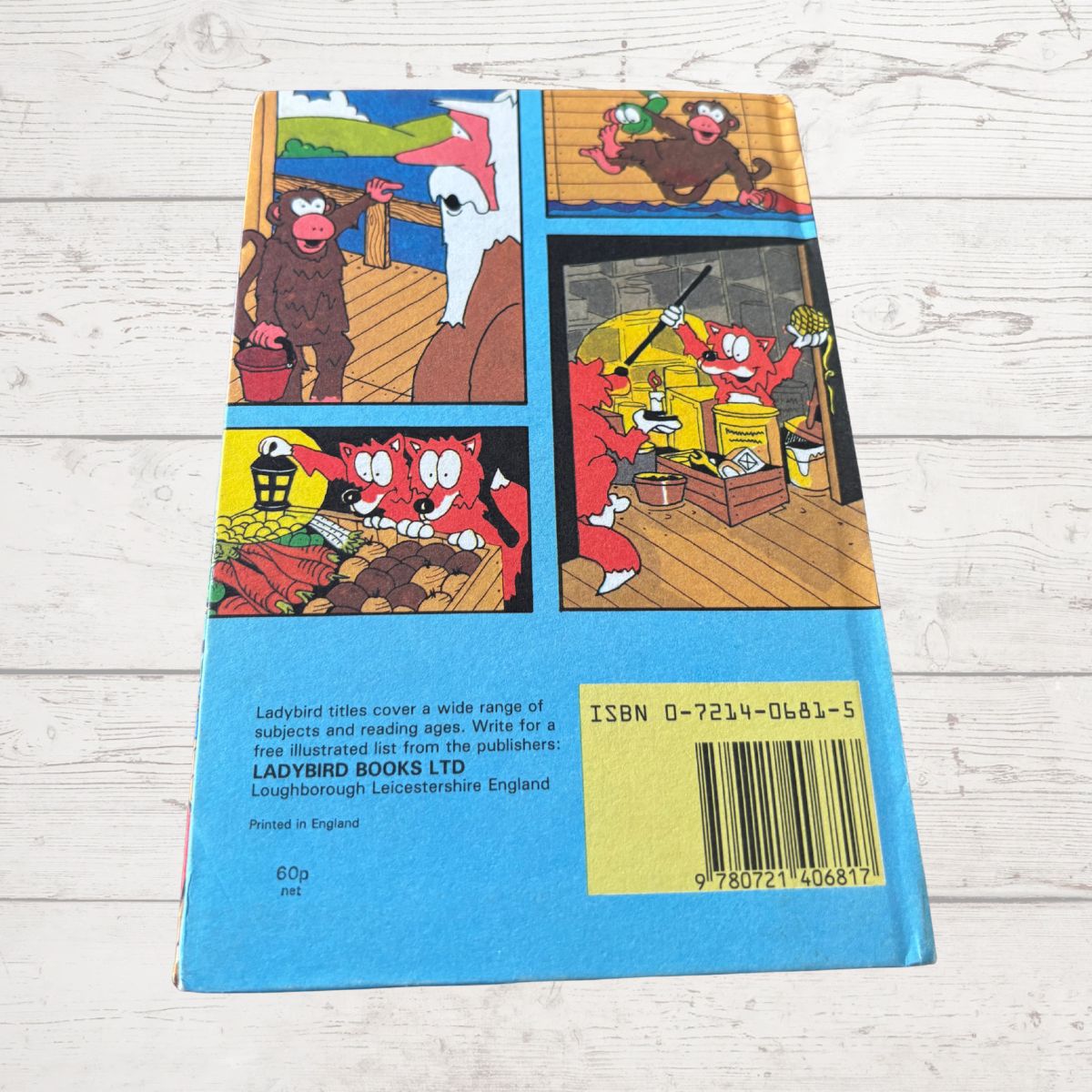 Back cover of a children's book with cartoon illustrations on a wooden surface