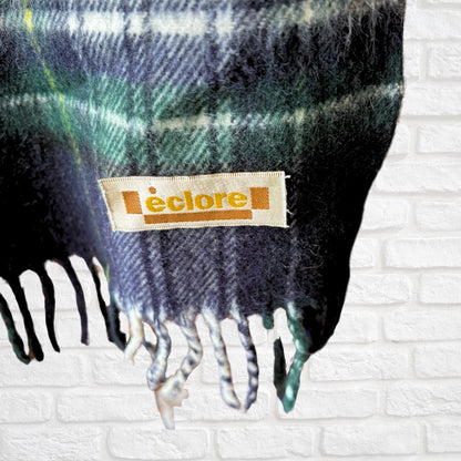 Plaid fabric with ‘eclore' label against a white brick wall background