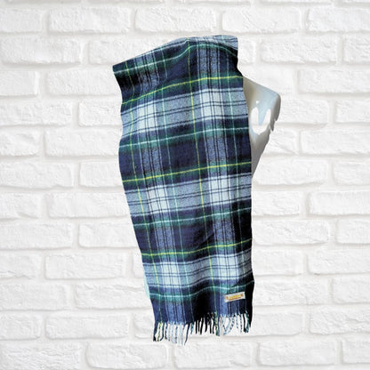 Plaid scarf on a mannequin against a white brick wall background