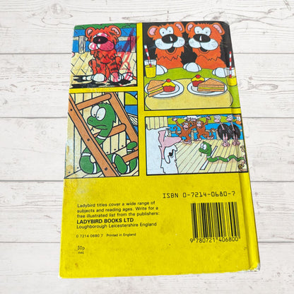 Back cover of a book with colorful illustrations and text on a wooden surface