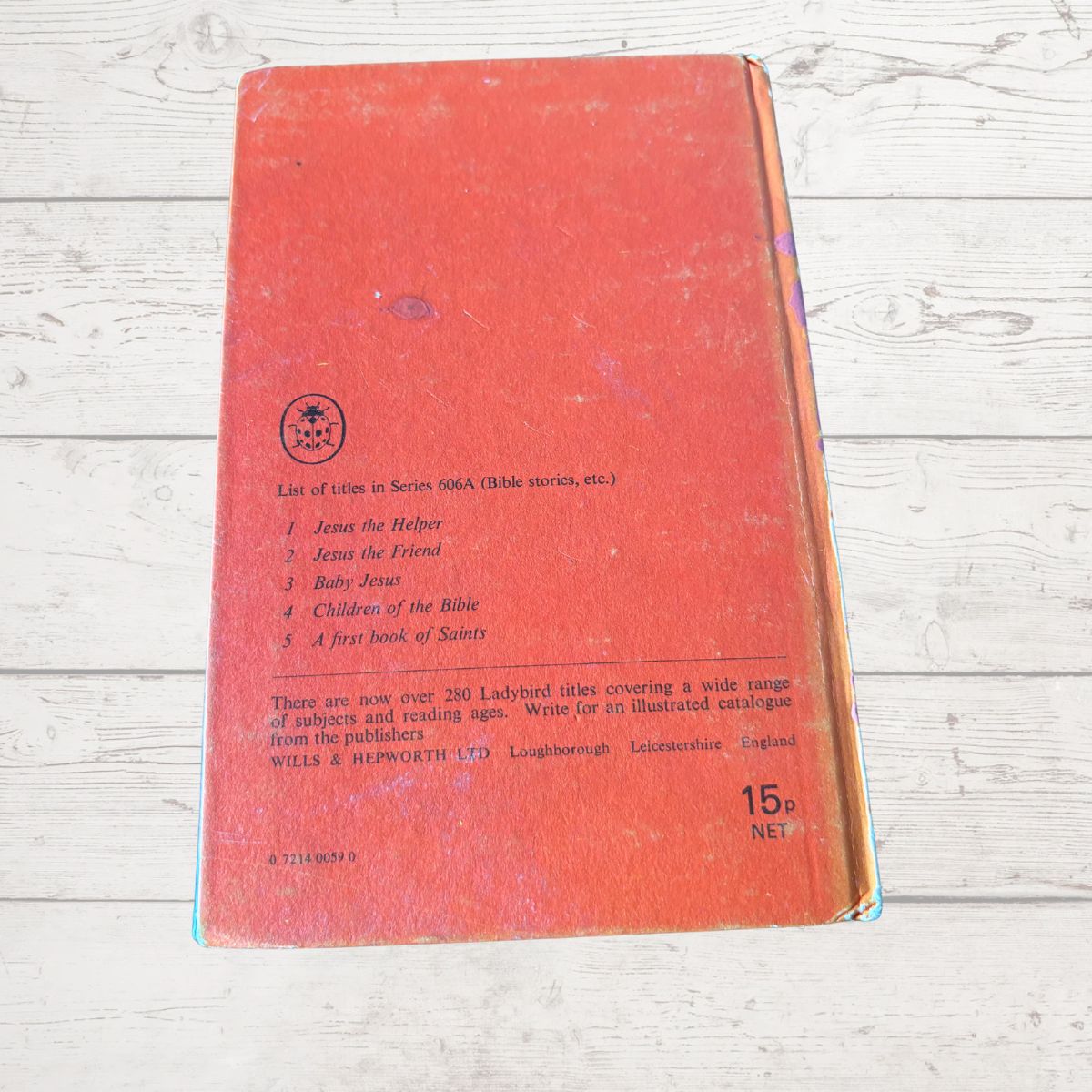Red book with text on a light wooden surface