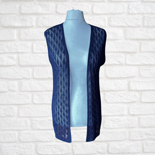 A sleeveless open-front lace vest in dark blue, displayed on a light blue mannequin torso against a white brick wall background.