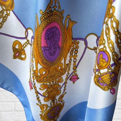 Decorative fabric with intricate gold and purple designs on a blue and white background