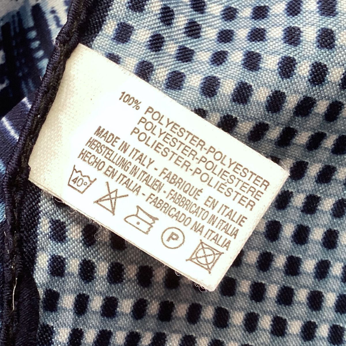 Clothing label on a fabric background with text and symbols
