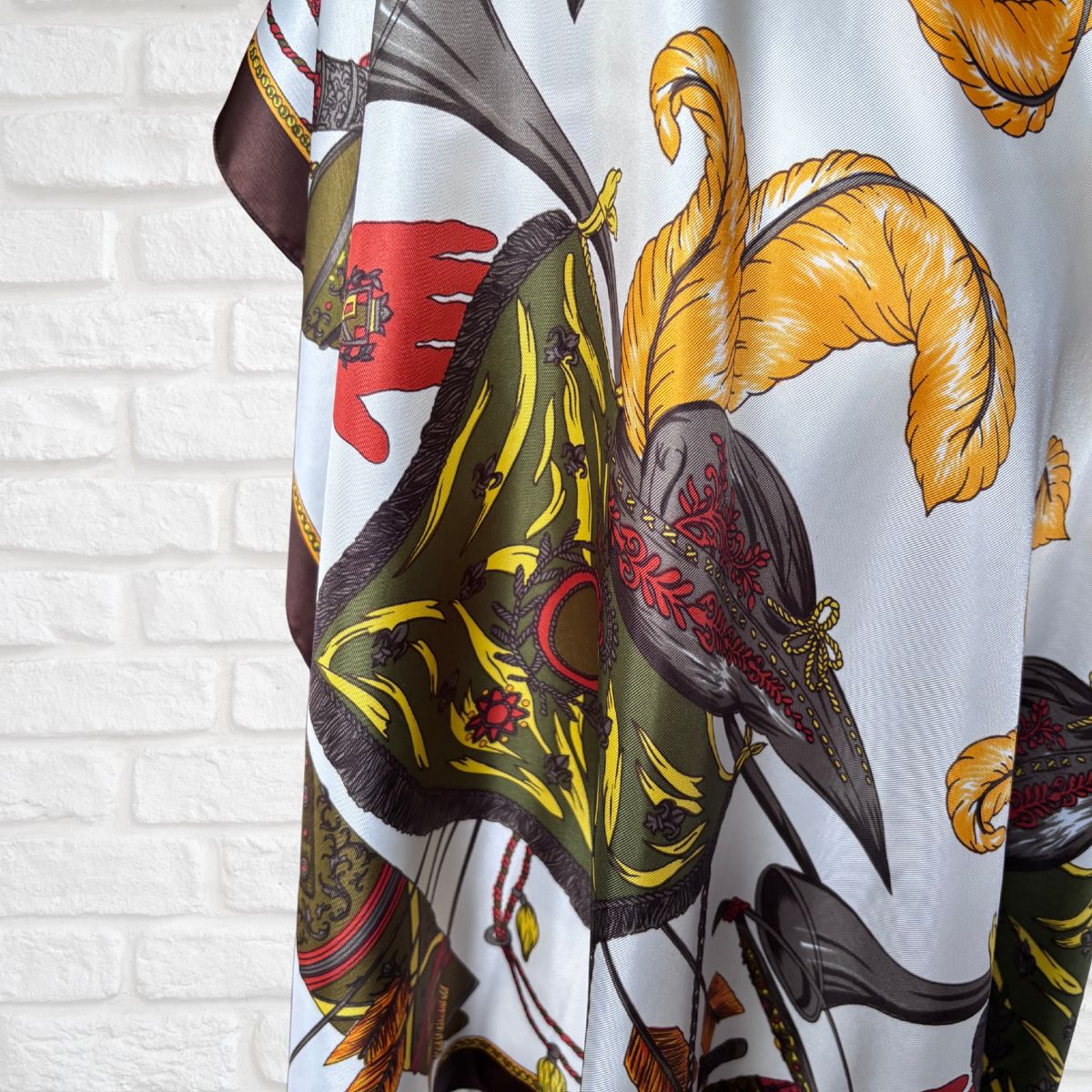 Colorful patterned fabric draped over a white brick wall