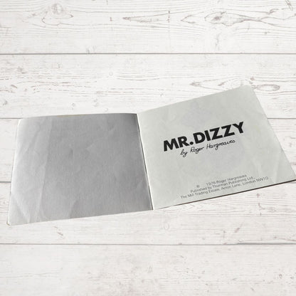 Book with 'MR. DIZZY' branding on a light wooden surface