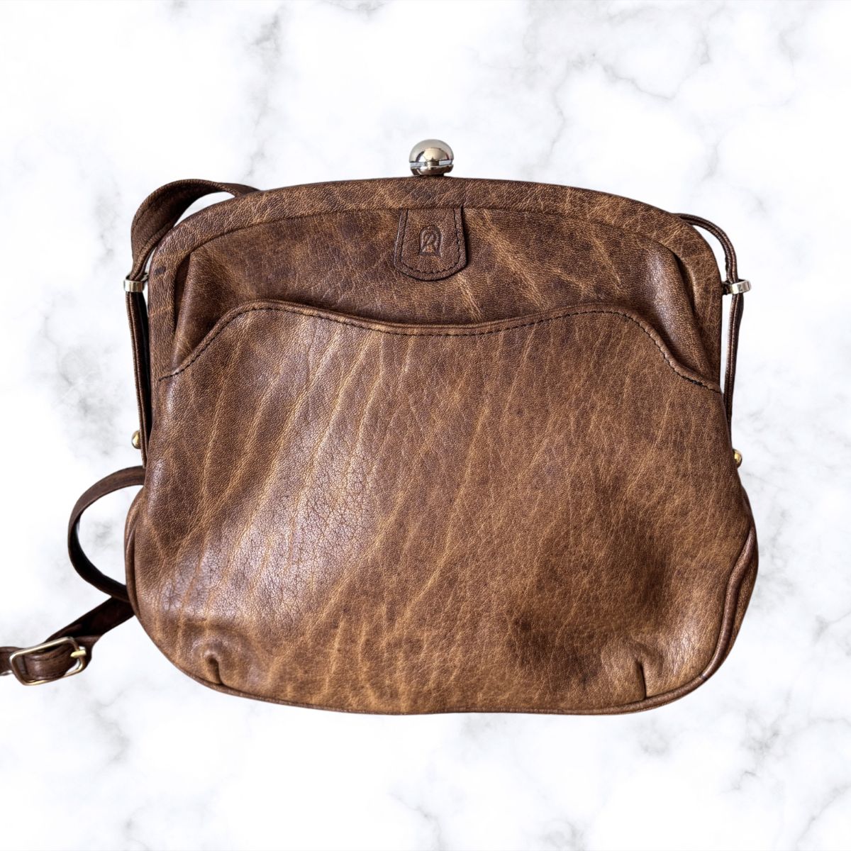 Brown leather look  handbag on a white marble background