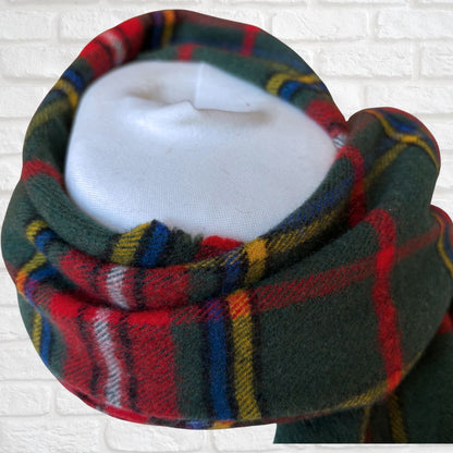 Plaid scarf on a mannequin head against a white brick wall background