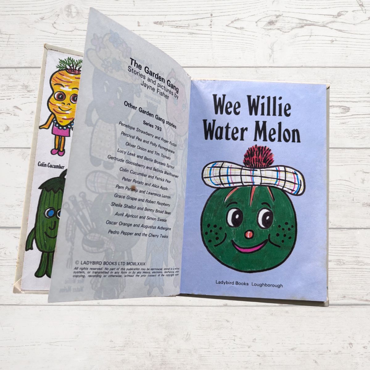 Open book showing 'Wee Willie Water Melon' character with Ladybird Books branding on a wooden surface.