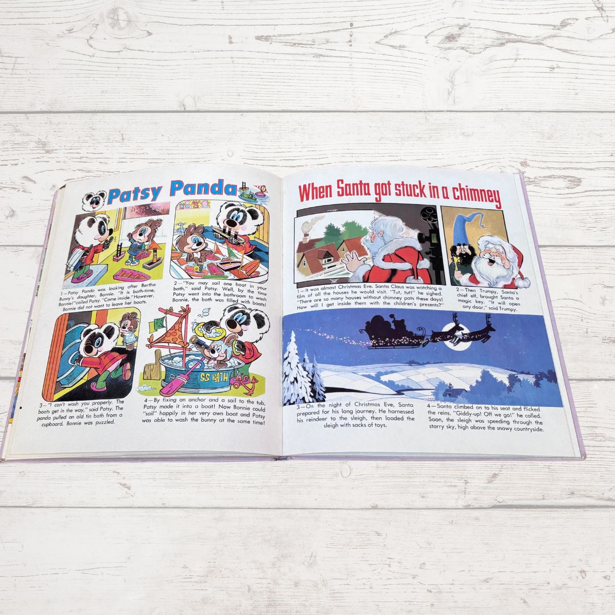 An open vintage children's comic book featuring 'Patsy Panda' and Santa Claus stories, displayed flat on a white wood plank surface.