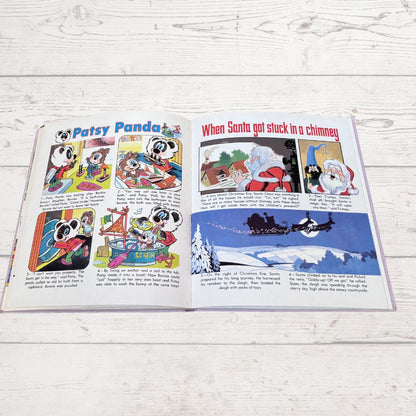 An open vintage children's comic book featuring 'Patsy Panda' and Santa Claus stories, displayed flat on a white wood plank surface.