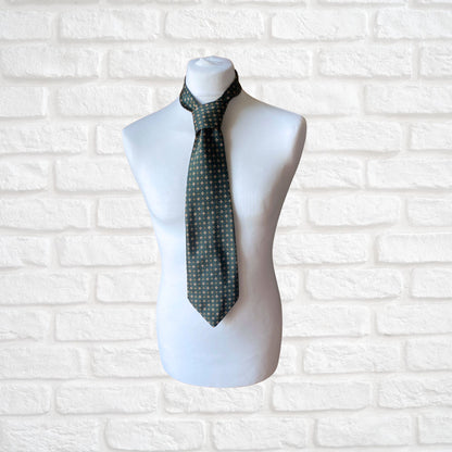 A green, orange and white geometric floral  print vintage 70s tie on a mannequin.