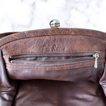 Close-up of a brown bag interior with a visible brand logo on a white background