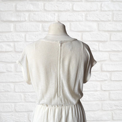 Off White dress on a mannequin against a white brick wall