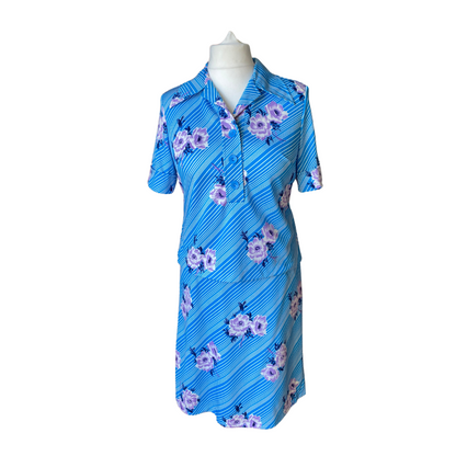 Blue and white striped two piece 70s skirt suit with large lilac and white flowers. Blouse has a dagger collar and short sleeves. Skirt is A line. 