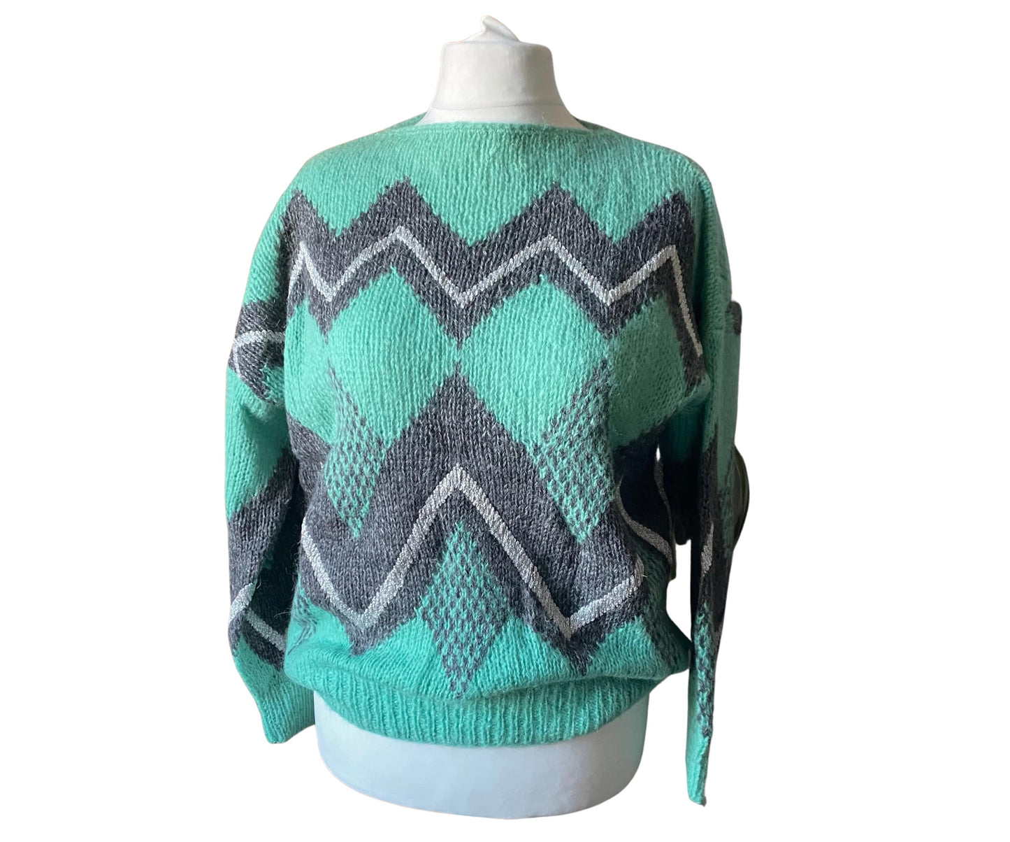 Mint green fluffy 80s jumper with grey and silver zig zag pattern.